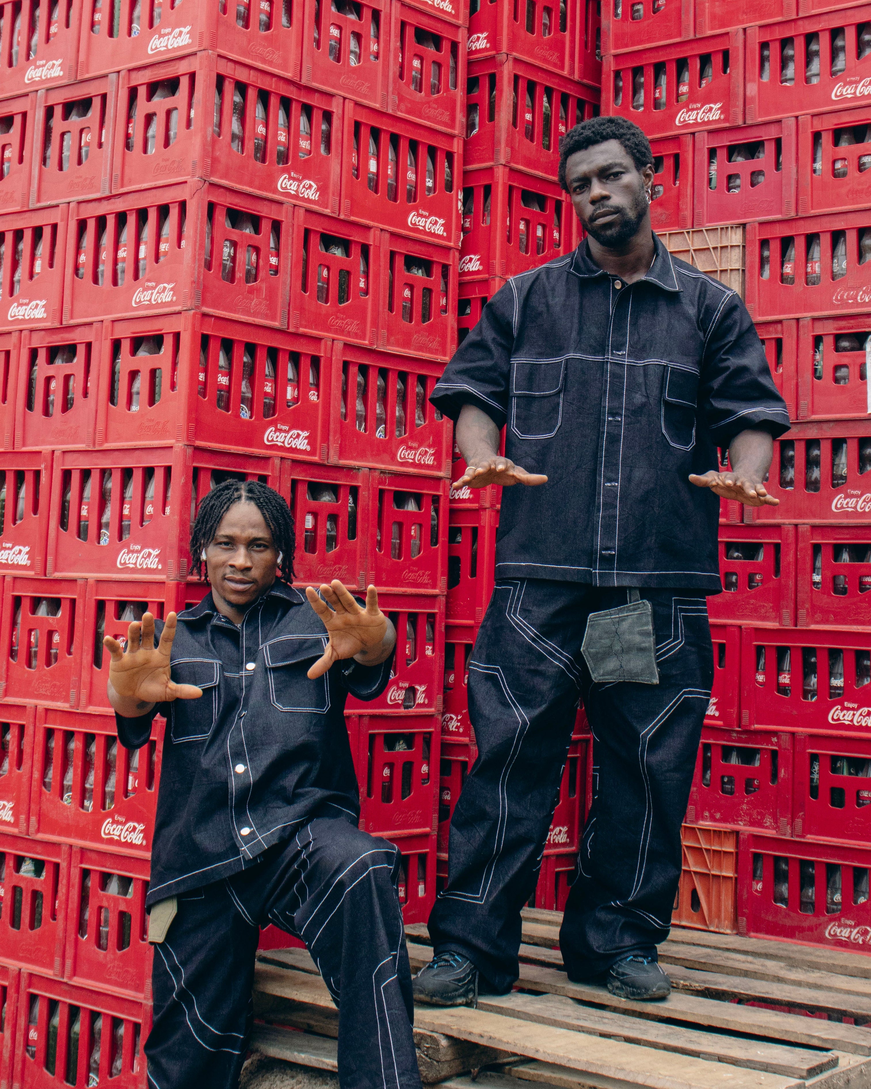 Two people posing in front of stacked red crates.